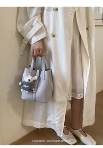 Exquisite light purple pebbled leather bucket bag with a cute bear charm held by a model
