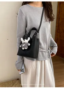 Minimalist black textured leather bucket bag for women with elegant crossbody strap