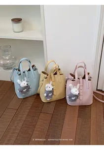 Three sophisticated bucket bags in blue, yellow, and pink with cute rabbit charms