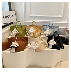 Vue détaillée de sacs cabas tressés et élégants avec de charmants pendentifs de lapin mignons.