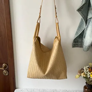 Vue détaillée du sac porté épaule en cuir tissé montrant la texture et la grande capacité.