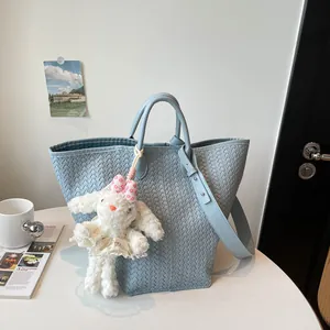 Sac cabas bleu tressé avec joli pendentif lapin en peluche, vue détaillée du sac épaule.