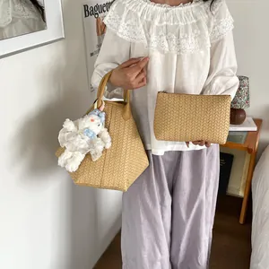 Vue détaillée du sac cabas tressé assorti d'une pochette et d'un pendentif lapin mignon.