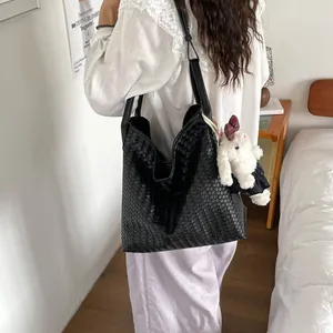 Vue détaillée du sac cabas en cuir tressé noir avec bretelles confortables et charm lapin.