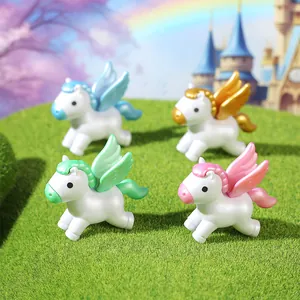Four colorful cartoon winged unicorn figurines on a green mossy hill with a castle