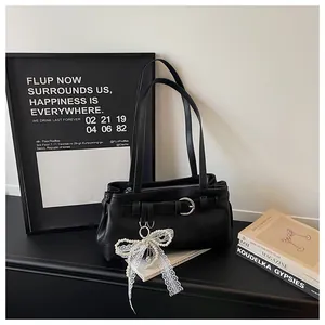 Vue de détail du sac porté épaule en cuir PU noir avec boucle et pendentif nœud perle dentelle.