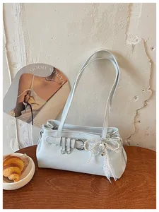 Vue détaillée du sac porté épaule bleu clair avec pendentif nœud perlé, style élégant.