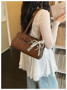 Detail de sac a epaule marron avec noeud dentelle perle, design mode retro chic.