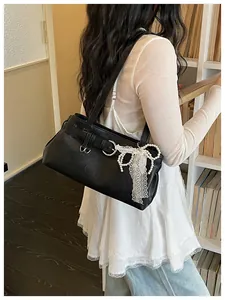 Élégant sac à épaule noir pour femme, doté d'une boucle métallique et d'un beau nœud.