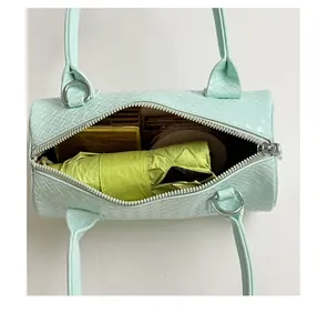 Interior view of mint green woven pillow bag showing capacity with everyday items