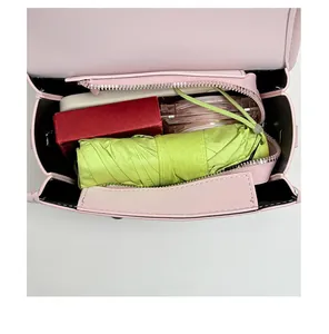 Close-up detail of small pink crossbody bag open interior capacity