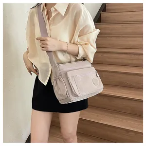 Multi-pocket nylon crossbody bag for women, casual travel shoulder bag with wide strap.