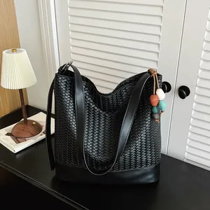 Trendy woven bucket shoulder bag for women, retro chic design, stylish underarm handbag.