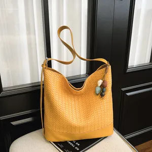 Trendy yellow woven bucket bag for women, stylish vintage single shoulder crossbody bag main view.