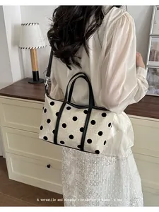 Vista detallada del elegante bolso tote de lona con lunares y asas negras muy práctico.