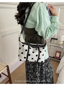 Bolso tote grande de lona blanca con lunares negros y correa para el hombro en modelo