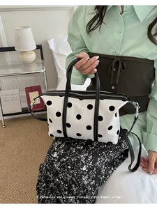 Vista detallada de un bolso tote de lona con lunares de estilo vintage para mujer en escena