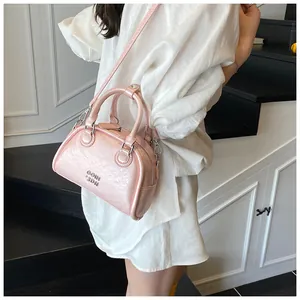 Detailopname van stijlvolle roze bowling handtas gedragen door model, trendy tas.