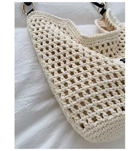 Close-up of cream hand-woven crochet tote bag showing lattice texture and gold rings.