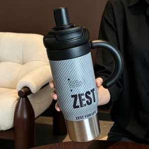 Close-up detail of stainless steel tumbler with large handle and modern striped design.