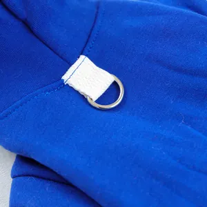 Close up detail of blue pet hoodie featuring white strap and metal d-ring attachment.