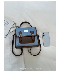 Vista detallada de una mochila retro de mezclilla y cuero marrón con un amuleto de corazón