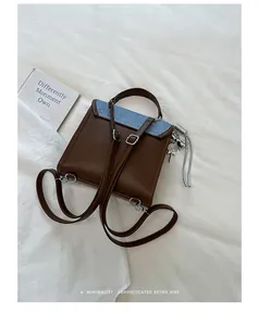 Mochila vintage para mujer en marrón y azul con un amuleto de piruleta plateado