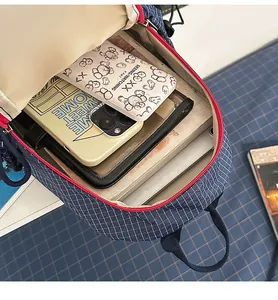 Mochila acolchada azul casual con cremallera roja de contraste, ideal para viajes y uso diario.