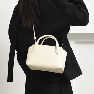 Minimalist cream bowling bag for women, stylish PU leather shoulder and crossbody bag.