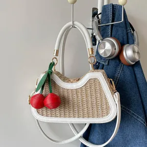 Sac à main en paille tissée pour femme avec charmant pendentif cerise rouge et bordure blanche.
