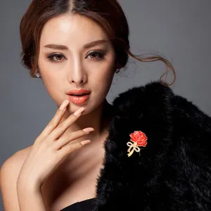 Detailed view of a red carnation rhinestone brooch worn on a black shawl for elegant outfits.