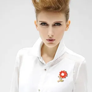Elegant carnation brooch featuring red enamel petals and a central pearl. Perfect jewelry.