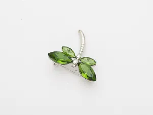 Vue détaillée d'une broche libellule en cristal vert élégante, bijou d'insecte chic.