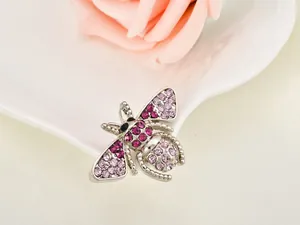 Close-up detail of a cute crystal bee brooch pin, sparkling pink rhinestones on alloy.