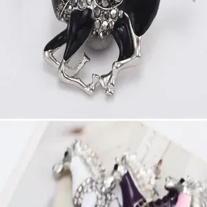 Close-up detail shot of rhinestone enamel horse brooch, stylish alloy clothing accessory.