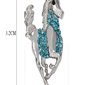 Close-up detail of the elegant silver-plated horse brooch with blue rhinestones.