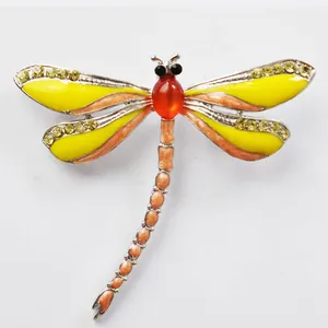 Detailed shot of a colorful enamel dragonfly brooch with sparkling rhinestones and gem.