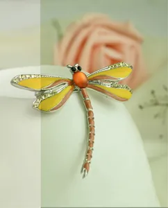 Close-up of a colorful enameled dragonfly brooch with sparkling rhinestones, elegant insect pin.