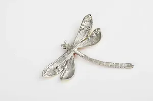 Detailed close-up view of the silver-tone dragonfly brooch back, showing pin and secure clasp.