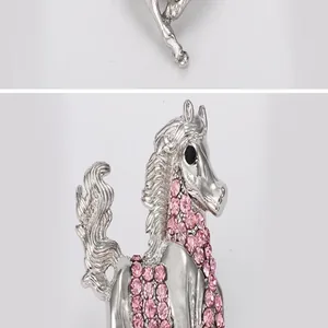 Close-up detail view of the sparkling silver-toned horse brooch adorned with pink rhinestones.