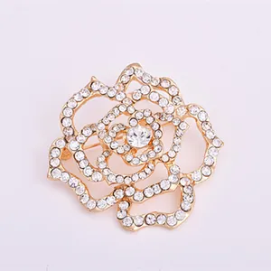 Close-up detailed view of a shining gold-plated alloy rhinestone rose flower brooch pin.