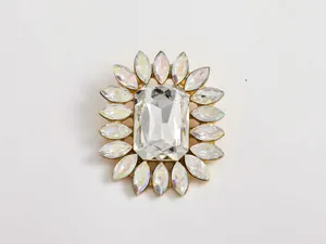 Close-up detail of a vintage style gold-tone crystal flower brooch with large center stone.