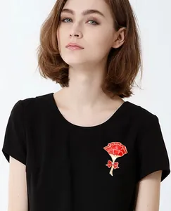Detailed close-up of the red enamel carnation brooch featuring a cute bow and sparkling crystal.