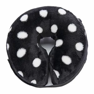Detail view of a black and white polka dot plush pet recovery collar for dogs, soft texture.