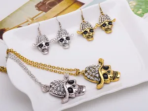 Detail shot of punk skull necklace and earrings set featuring rhinestone and gold silver finish.
