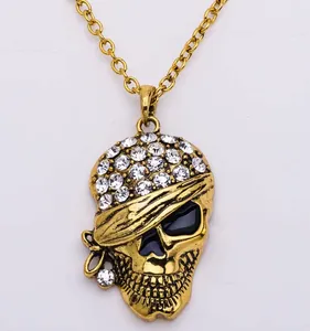 Punk style gold skull pendant necklace with sparkling rhinestones and black enamel details.