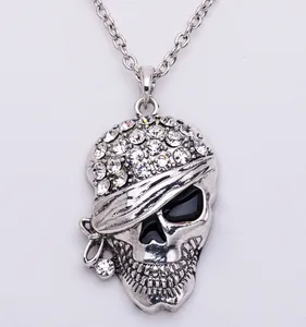 Detail shot of silver punk skull pendant necklace with sparkling rhinestones and black enamel eyes.