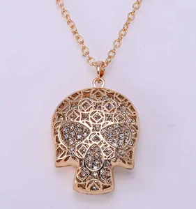 Close up detailed view of stunning rhinestone hollow skull pendant necklace in shiny gold color.