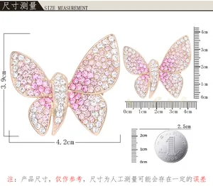 Detailansicht der funkelnden rosa Strass Schmetterling Brosche mit präzisen Maßangaben und Lineal.