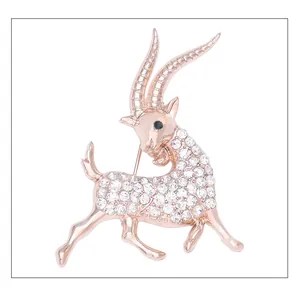 Broche chèvre en métal ton or rose décorée de strass cristaux blancs brillants pour femmes.